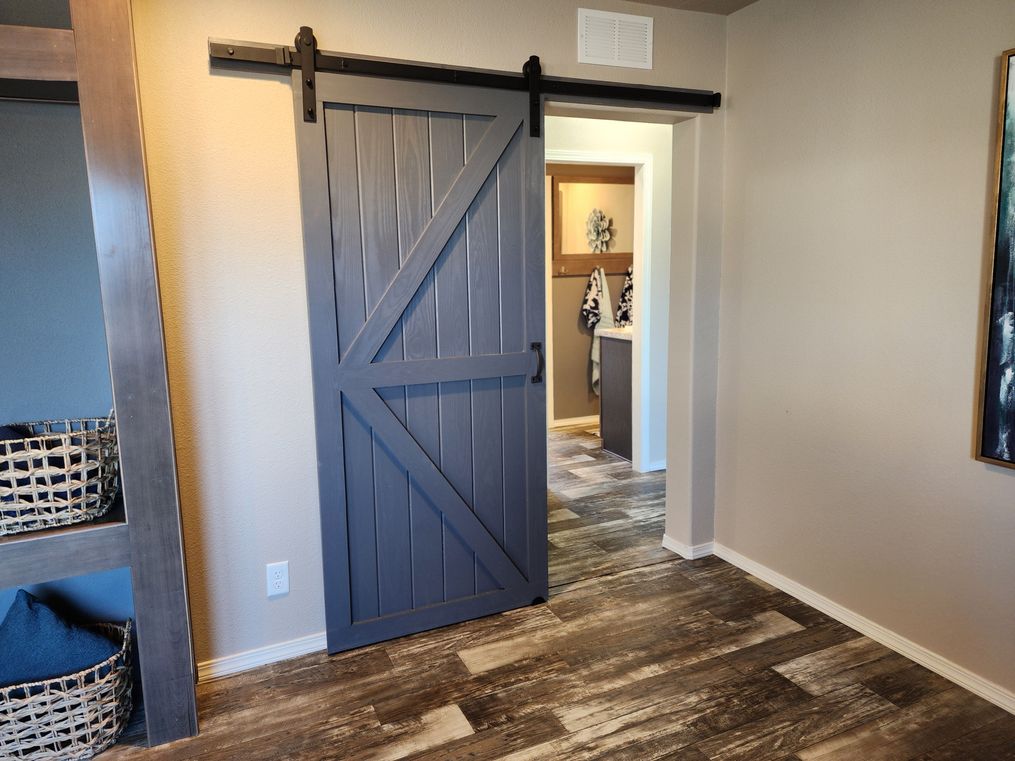 Barn door separates 3 guest bedrooms and guest bathroom wing