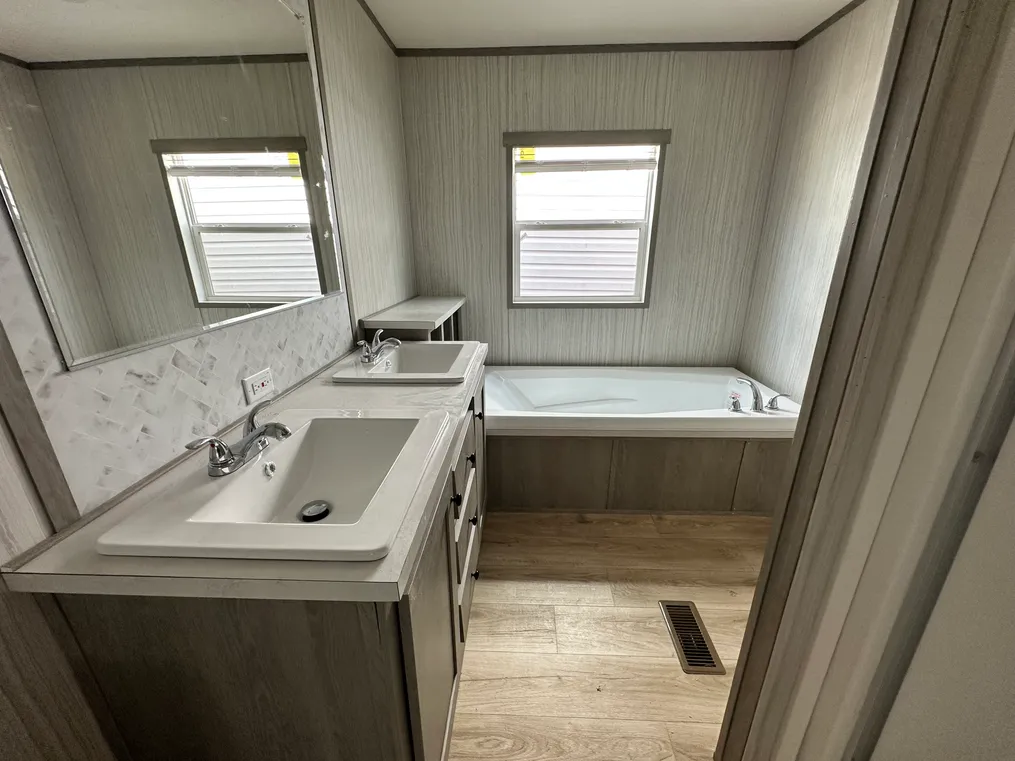 Primary bath with dual vanity, soaker tub, & walk-in shower.  