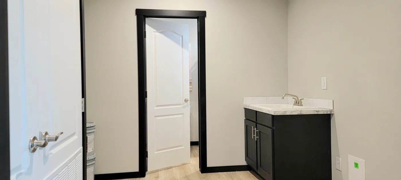 Utility room with furnace and hot water access and sink. Door access to full bath.