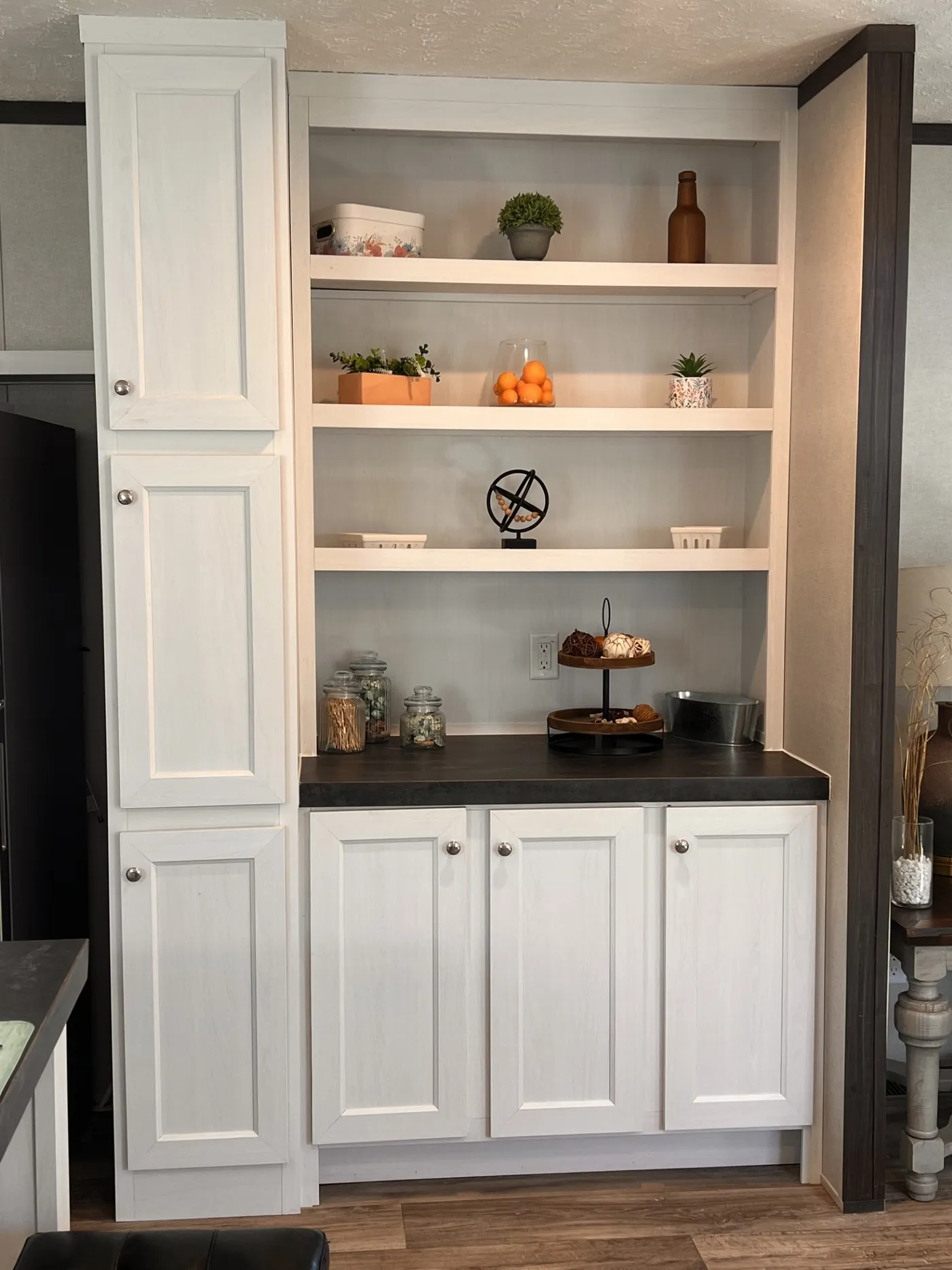 Charming, built-in coffee bar with open shelving, generous cabinet storage, and a dark countertop-perfect for creating a dedicated coffee station while keeping everything organized and within reach.