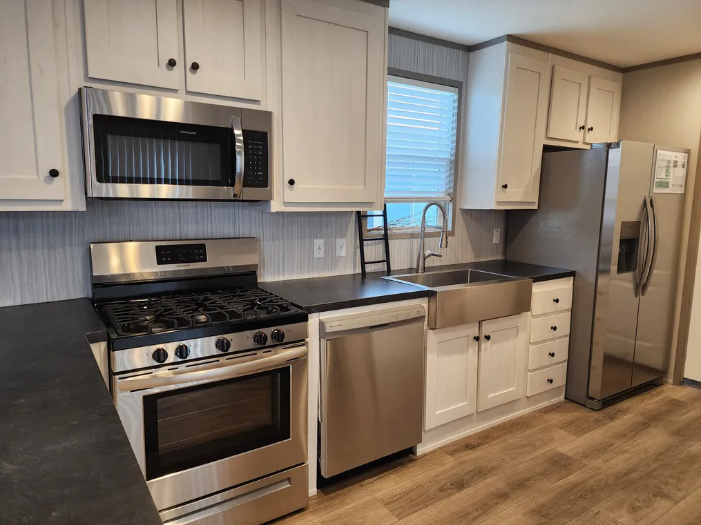 Kitchen with stainless steel Frigidaire appliances, extra attached appliance space and a pantry